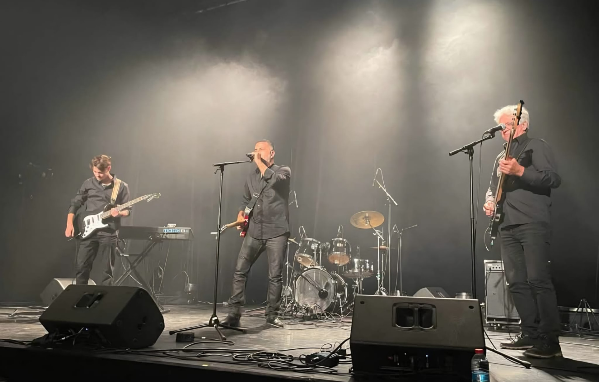 Le groupe sur scène dans la fumée et les contre-jours